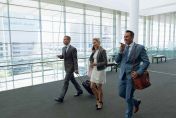 Business travellers checking phone in airport lounge with luggage